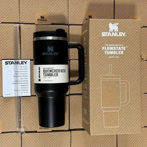 Black Stanley tumbler with packaging on a cardboard background