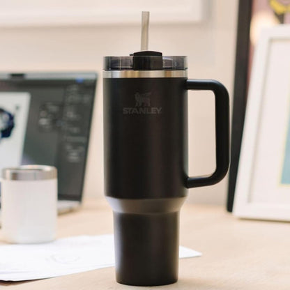 Black Stanley mug with a handle on a desk