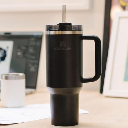 Black Stanley mug with a handle on a desk